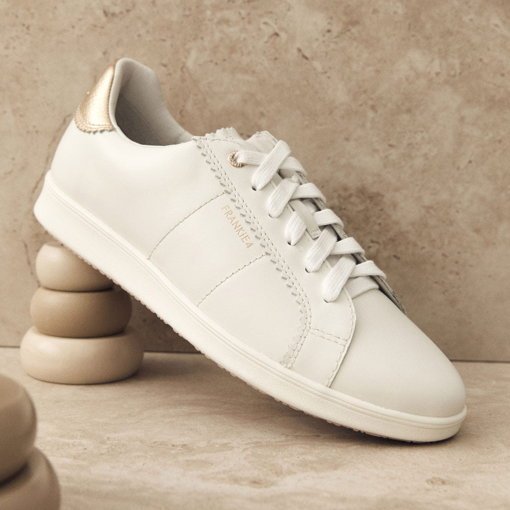 White sneakers store with gold trim